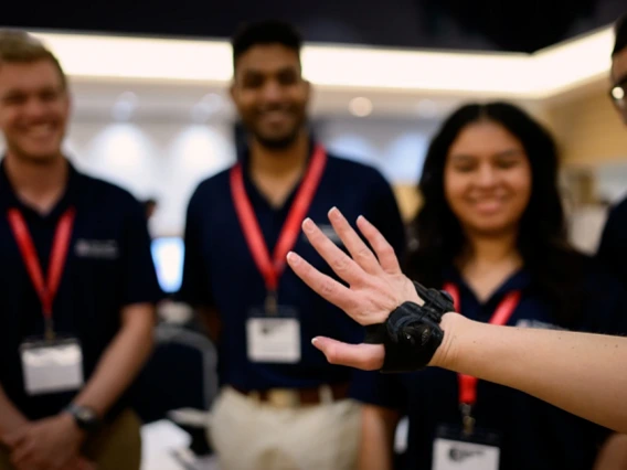 A team of engineering students around a wrist brace at Design Day