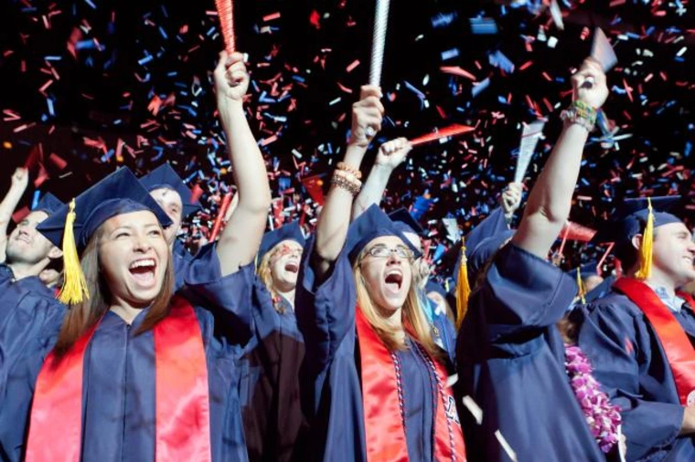 students in regalia, cheering