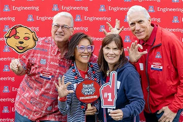 four people, smiling with Univ of AZ SWAG